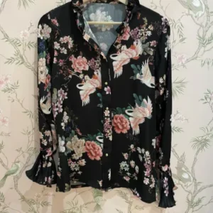 camisa con puño plisado y flores rosas